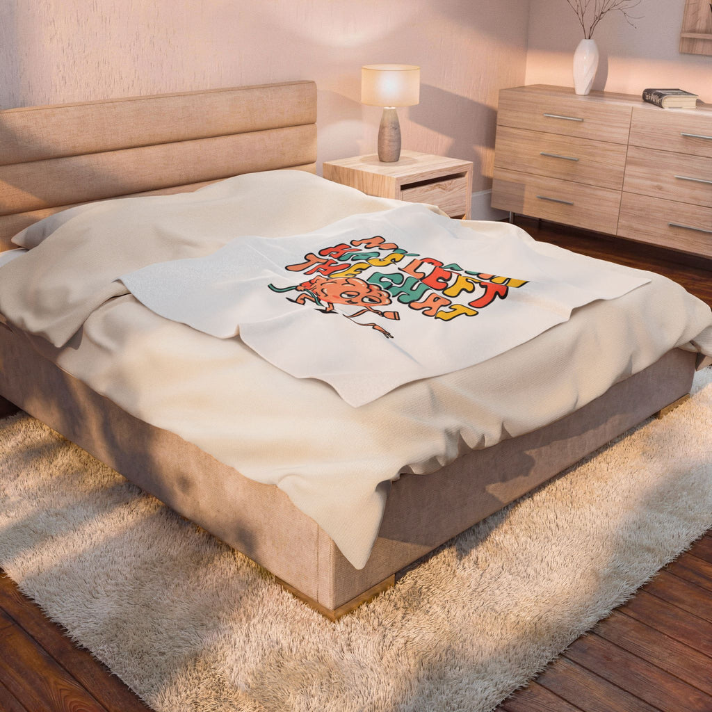 Bedroom with a bed featuring a decorative blanket and a lamp on a nightstand.