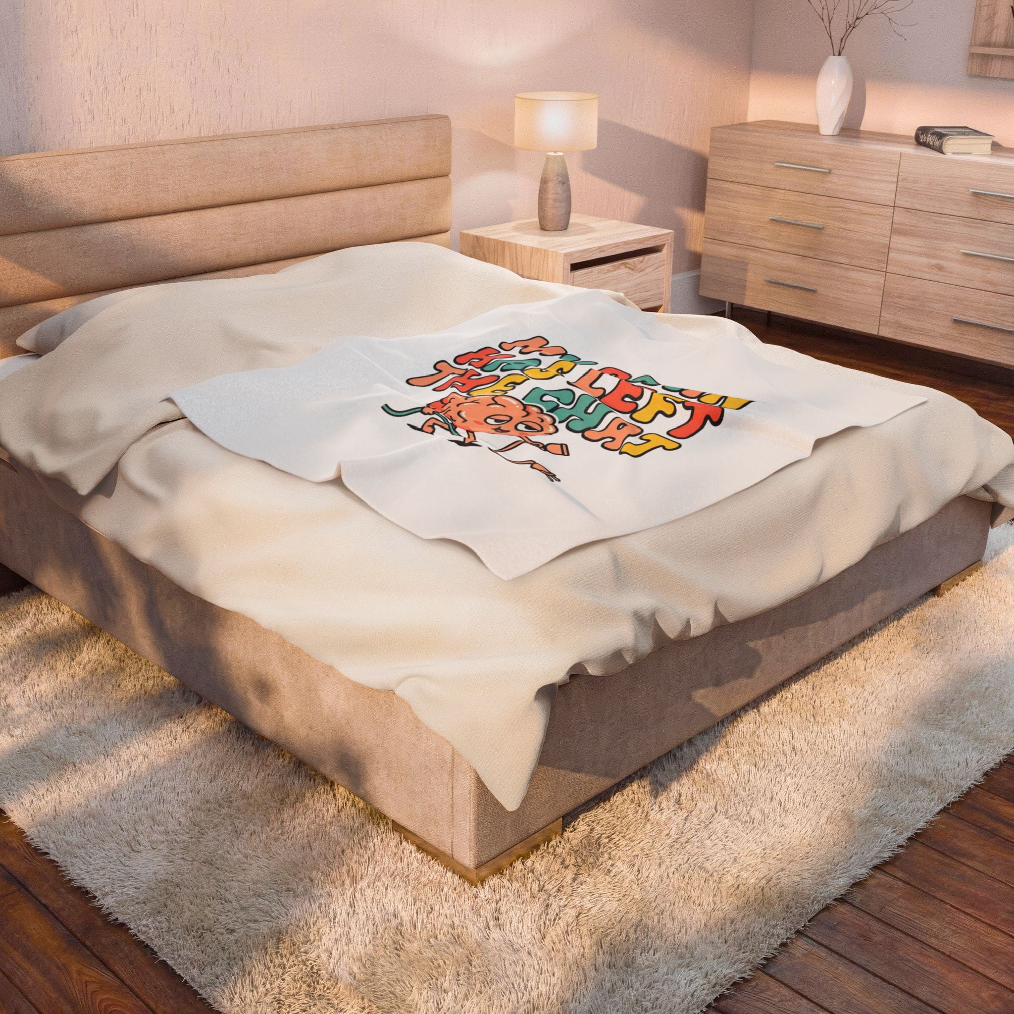 Bedroom with a bed featuring a decorative blanket and a lamp on a nightstand.