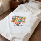 White towel with colorful graphic and text on a bed in a bedroom setting