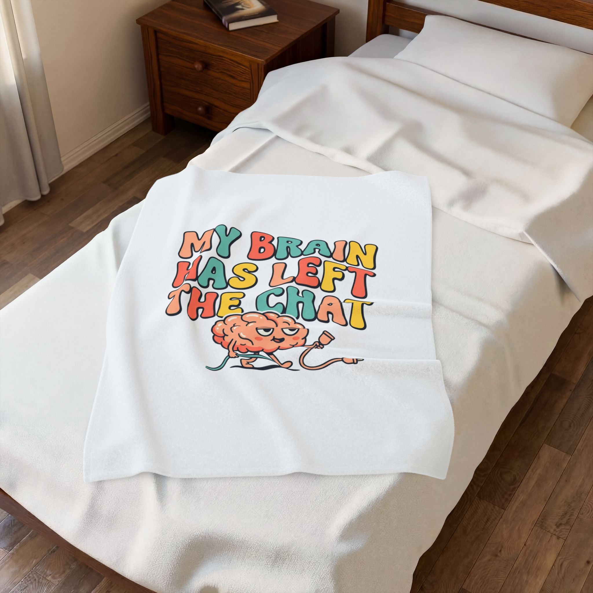 White towel with colorful graphic and text on a bed in a bedroom setting