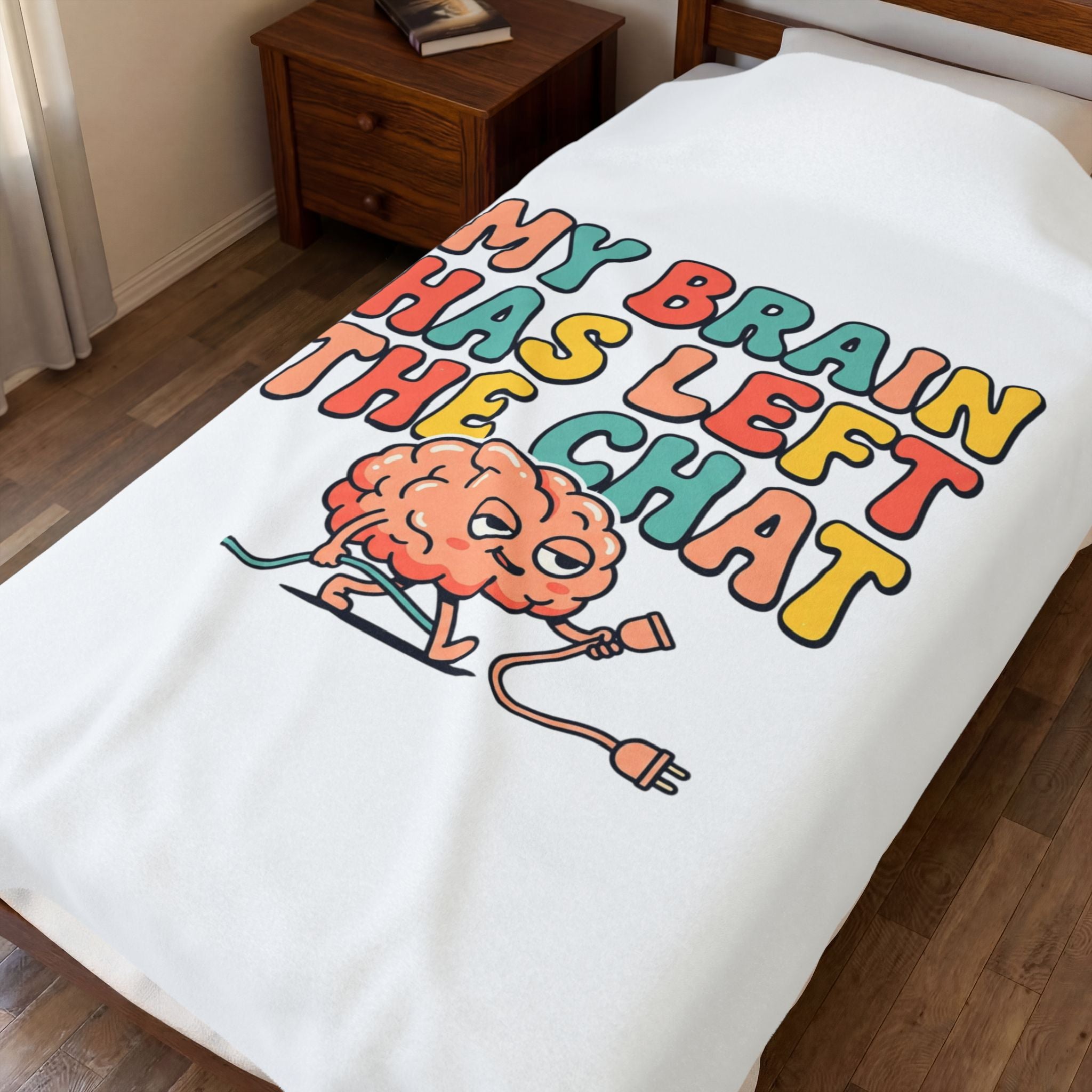 Blanket with a colorful graphic of a brain and text on a bed in a bedroom.